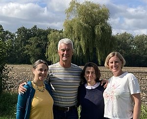 4 Personen auf dem Bild vor einem Acker stehend